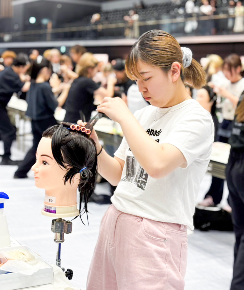 モデルの髪の取り方に真剣になっている女性