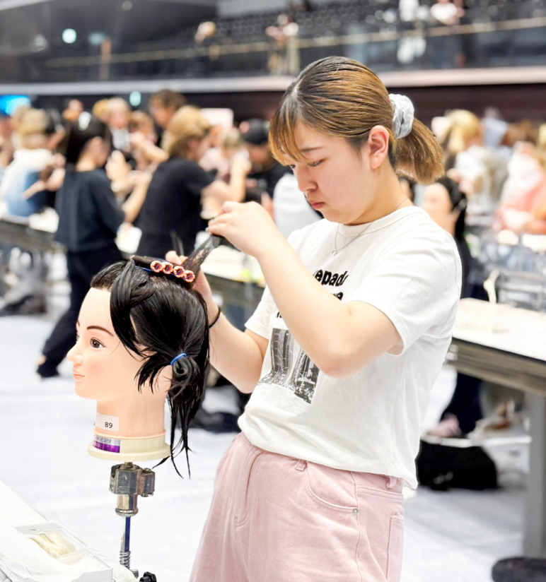 モデルの髪の取り方に真剣になっている女性