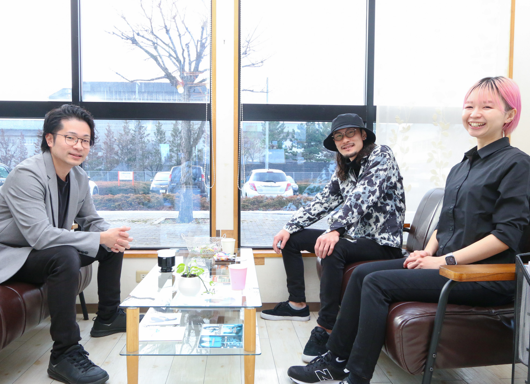 腰を掛け、気さくにこちらを見つめる3人